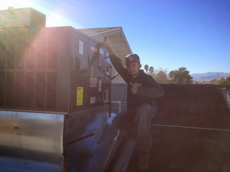 HVAC technician performing AC Tune-Up on a rooftop unit in Whitehouse